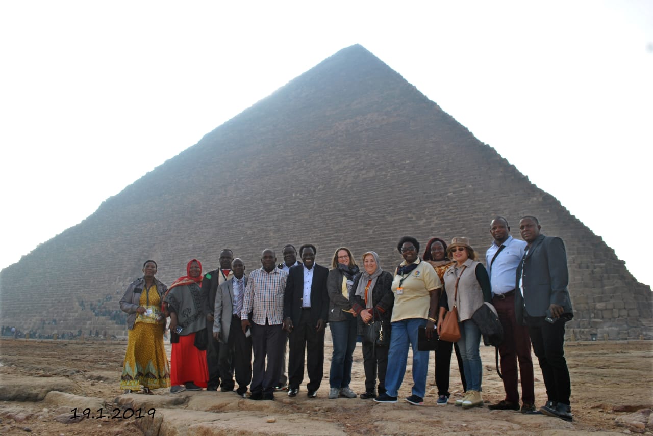 A group of people in front of a pyramid